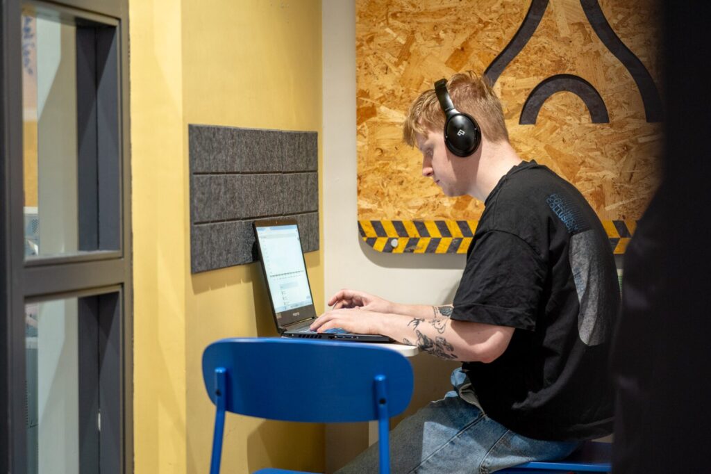 A man sitting at a desk using a laptop doing SEO Services